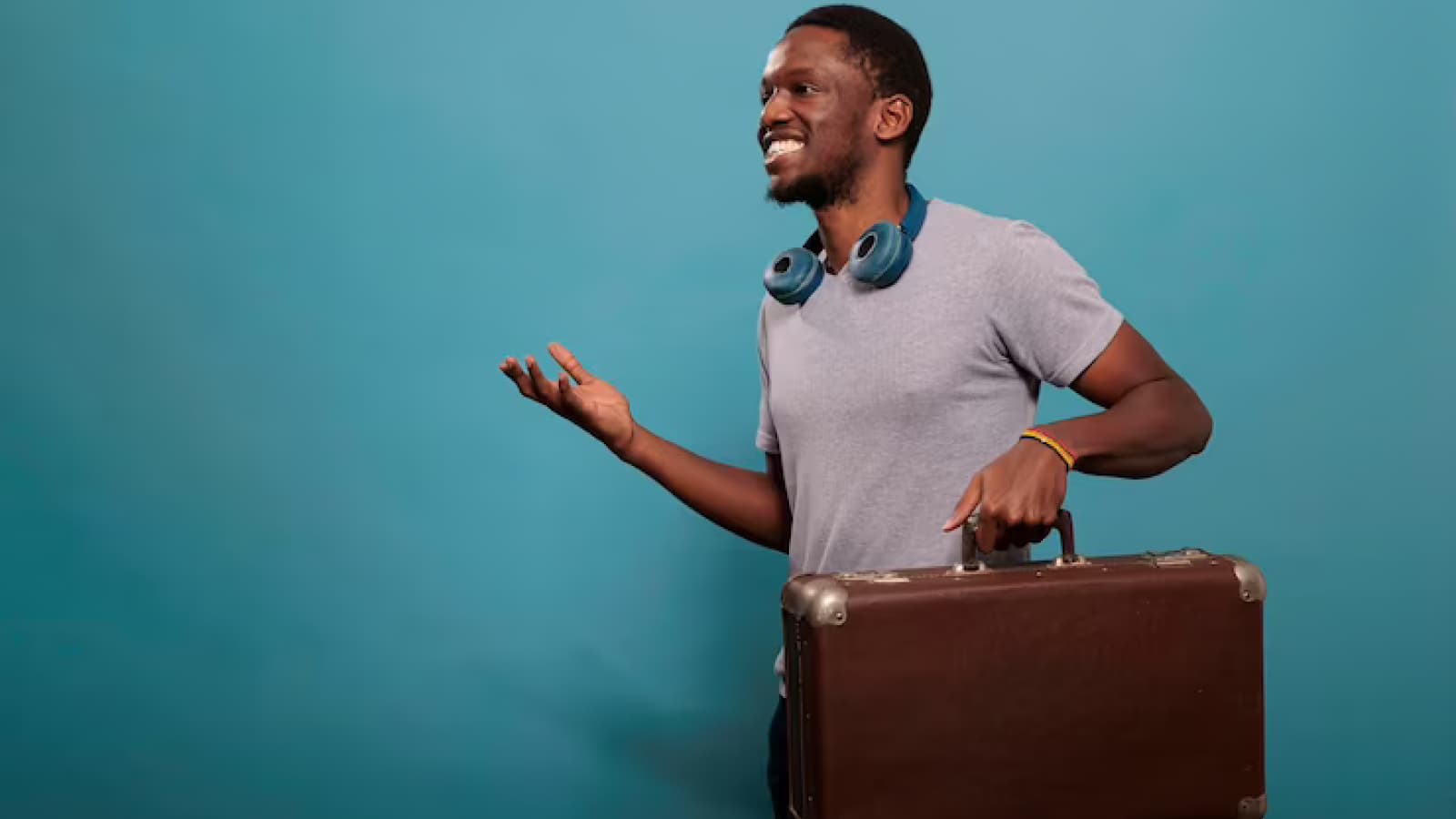 Homem sorrindo com mala na mão