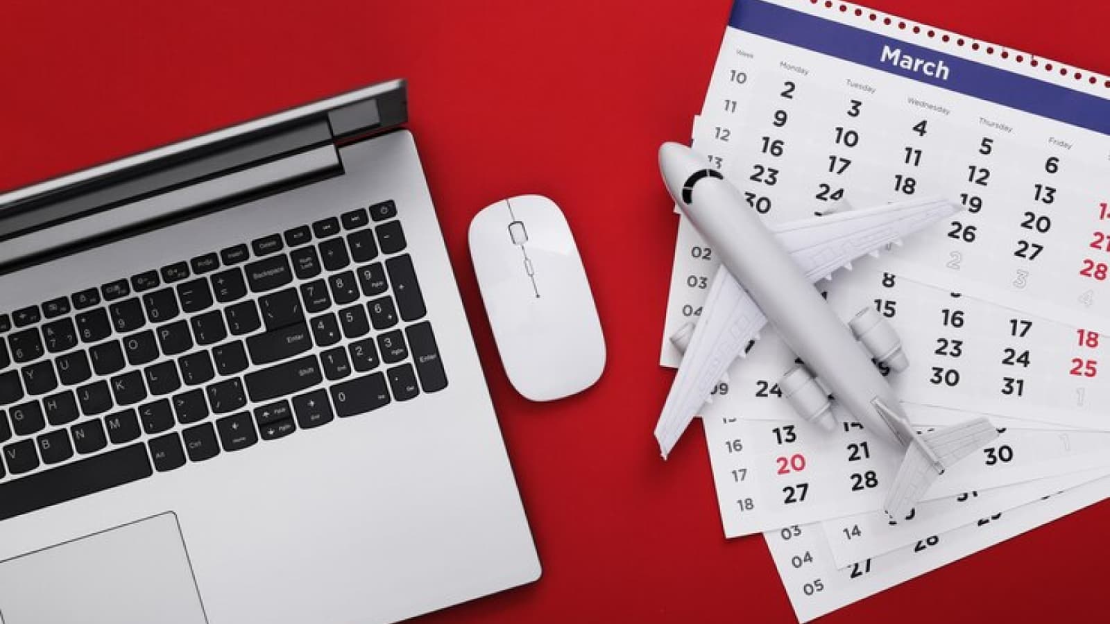 Calendário ao lado de notebook e avião em miniatura