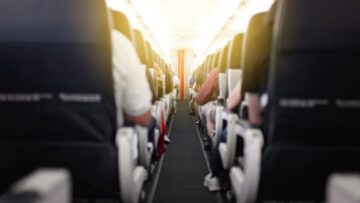 Corredor de avião com poltronas ocupadas