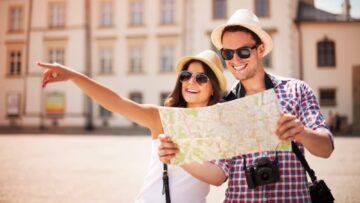 Homem e mulher de óculos e chapéu com mapa