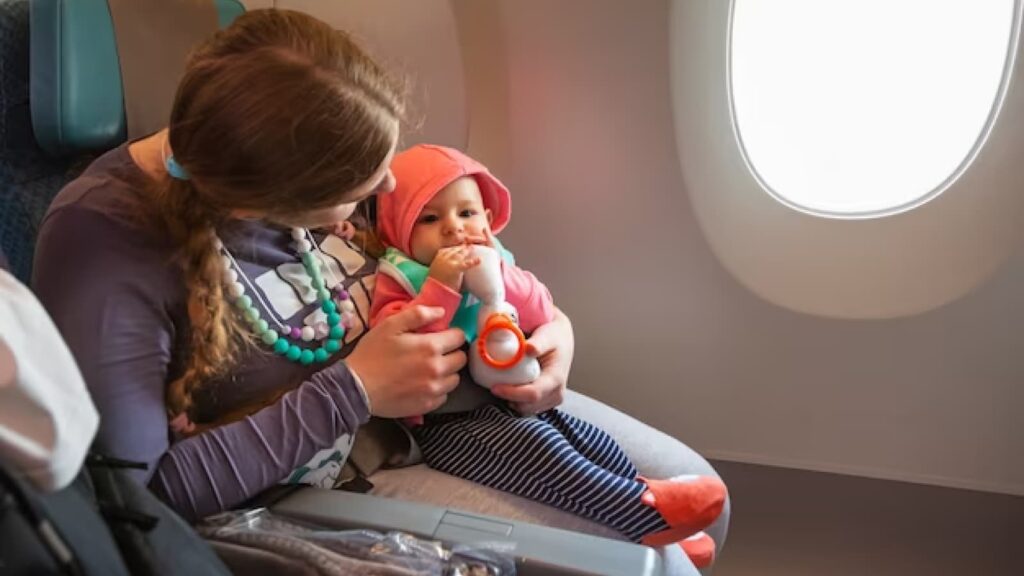 Mulher na janela do avião com bebê com brinquedo